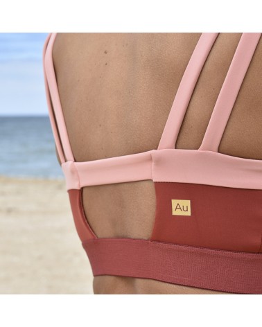 Brassière Harmony de couleur corail portée par un mannequin en gros plan de dos à la plage